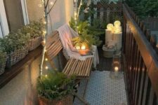 a narrow balcony with a boho rug, a bamboo bench with a blanket, candle lanterns, string lights and lanterns