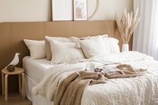 a neutral boho bedroom with a terracotta accent, a pendant lamp, woven baskets, layered bedding
