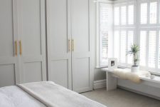 a neutral modern bedroom with ddove grey wardrobes, neutral furniture and a pendant lamp