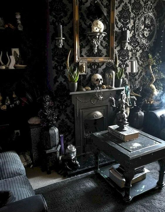 a refined Gothic living room with catchy wallpaper, skulls, black furniture, a mini fireplace, some greenery and exquisite touches
