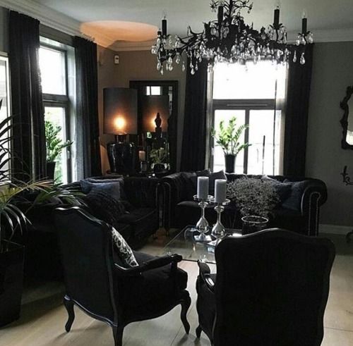 a refined Gothic space with elegant black furniture, a black chandelier and potted greenery