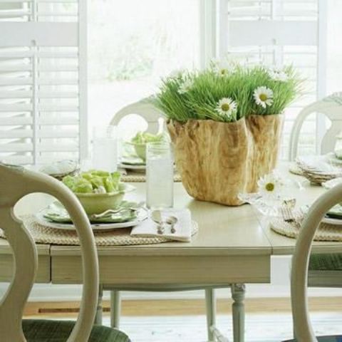 a rustic spring tablescape with woven chargers, green porcelain, a catchy wooden planter and white blooms