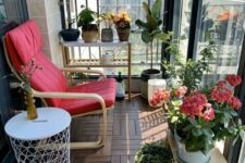 a small balcony with an IKEA chair, a plant stand, lots of potted plants and blooms and a side table is welcoming