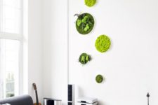 a small yet bright arrangement of moss and greenery wall art pieces adds to the modern space