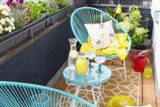 a vivacious summer balcony with blue furniture, colorful pillows and textiles and some poted blooms is welcoming
