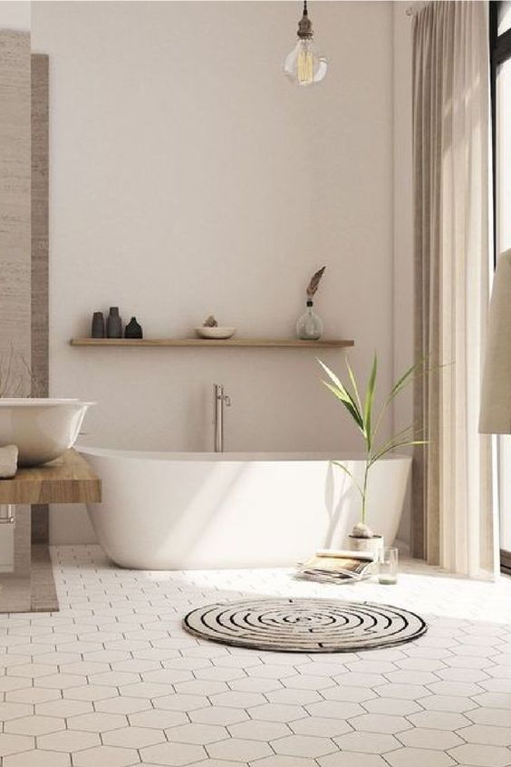 a warm contemporary bathroom with a hex tile floor, an oval tub, a floating vanity, a floating shelf and a round rug