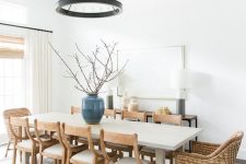 a welcoming modern farmhouse dining room with a console, a pendant black lamp, a long table, wooden and woven chairs