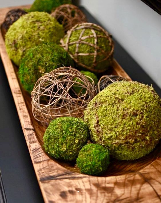 a wooden bowl with vine balls and moss ones is s stylish centerpiece or decoration for spring