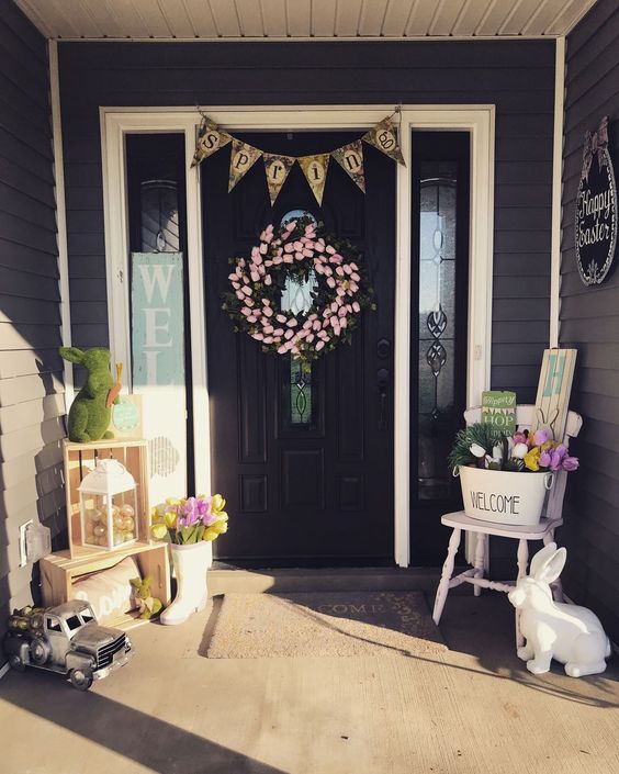 Easter porch decor with bunnies of moss and plastic, with colorful tulips, a tulip wreath and a bunting