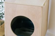a Scandinavian cat litter box cover of plywood, with a round entrance and on legs can double as a side table