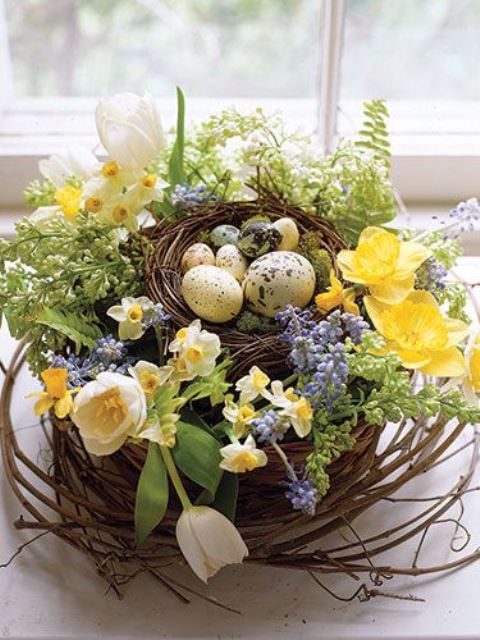 a beautiful blooming spring centerpiece of a nest with tulips, daffodils, hyacinths and fake eggs and moss