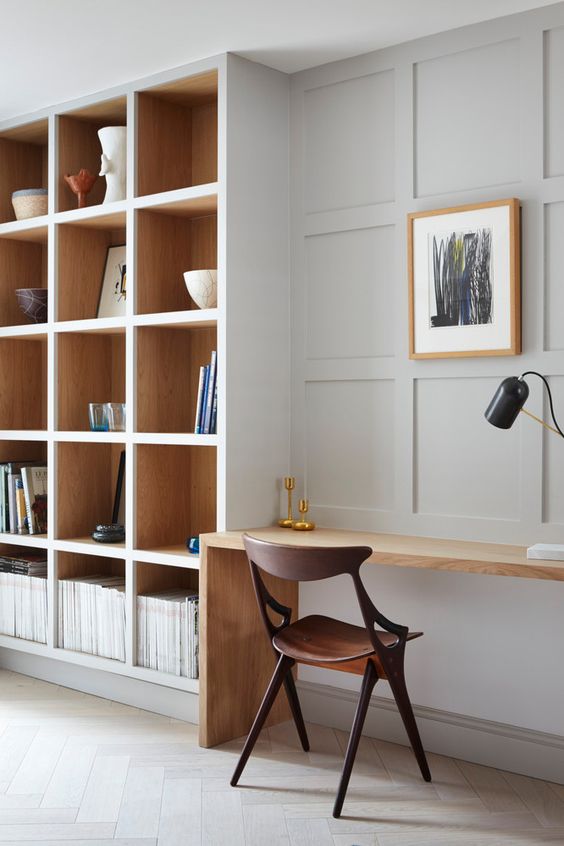 A beautiful minimalist home office with built in bookshelves and a small built in desk is a stylish space