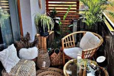 a boho balcony with rattan chairs and a table, a boho pouf and a pillow, a jute rug, potted greenery and candle lanterns is small but cool