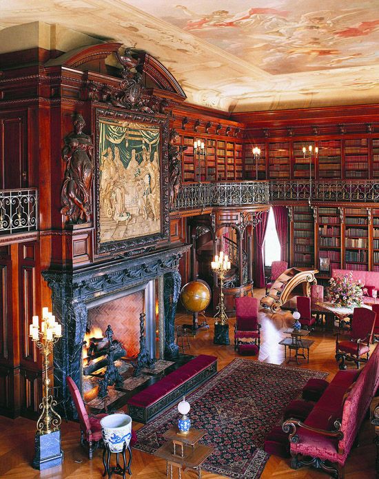 a bold Gothic library in red and fuchsia, with bookcases covering all the walls, a large fireplace and a statement artwork, fuchsia and purple Gothic furniture
