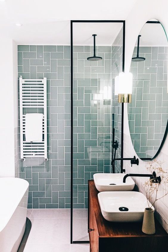 a bright contemporary bathroom with aqua green tiles in the shower space, a floating vanity and a tub