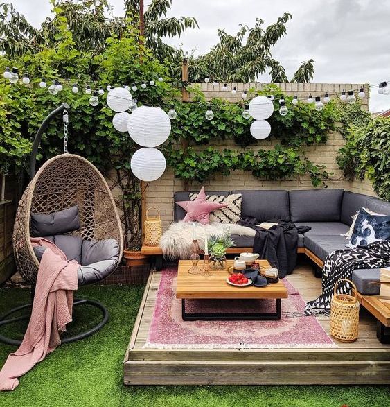 A bright spring terrace with a built in bench, a table and an egg shaped suspended chair, boho printed textiles and rugs