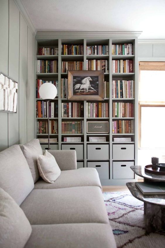 A built in bookshelf unit with box drawers and a large artwork on it is perfect for a contemporary space