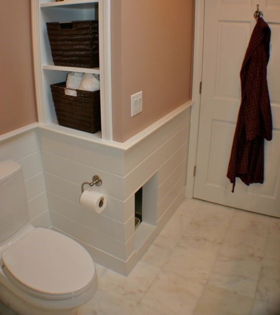 a built-in cat toilet unit in the powder room, with an entrance and clad with tiles to perfectly match the house