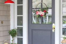 a chic spring porch done with bright potted blooms, candle lanterns and a modern hoop floral wreath on the door