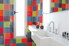 a contemporary bathroom clad with super bright tiles but  with a white built-in vanity and shelf plus a bold rug is amazing
