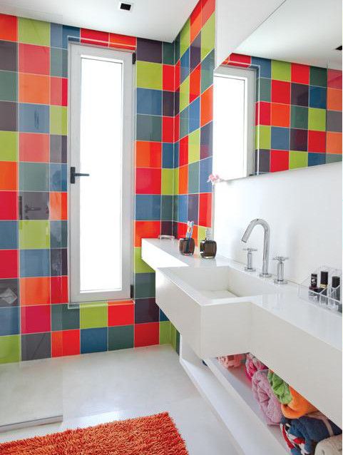 A contemporary bathroom clad with super bright tiles but  with a white built in vanity and shelf plus a bold rug is amazing