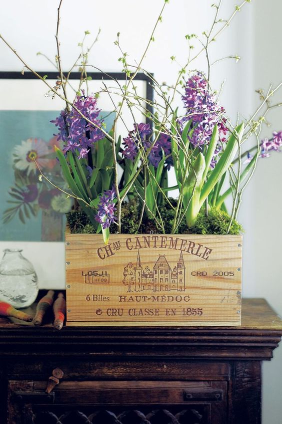 a crate with moss, purple hyacinths and blooming branches is a lovely idea for a spring space