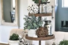 a farmhouse kitchen stand with cotton, greenery in pots, vine balls and silver jars