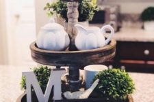 a farmhouse kitchen stand with greenery, letters, an artwork, porcelain and mugs for spring