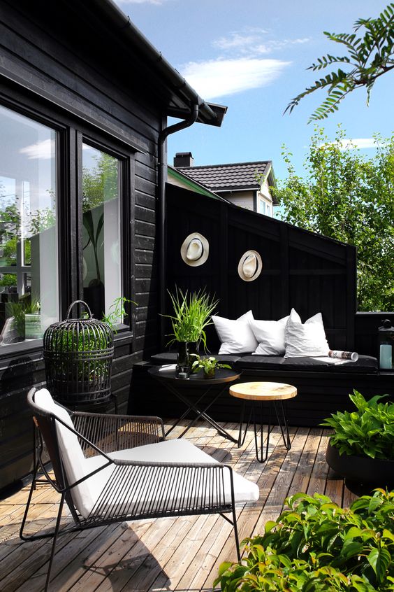a fresh spring Scandinavian terrace in black and white, with potted greenery and greenery in cages