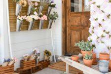 a fun idea to turn your porch into a flower market hanging blooms in buckets and placing them everywhere