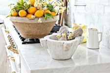 a large bowl with lemons and white blooms is a bold and cool idea for spring kitchen decor