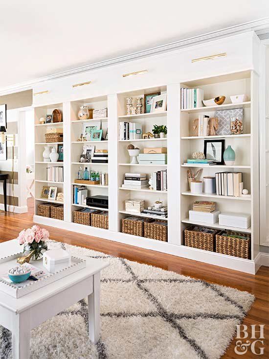 A large built in bookshelf unit with lots of books, vases, baskets and candles is a cool idea for a home office