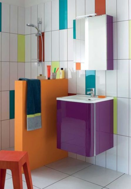 a modern colorful bathroom done with white, neon yellow, orange, teal and turquoise skinny tiles and with a bright half wall and vanity is wow