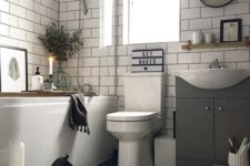 a monochromatic bathroom with a hex tile floor, subway tiles on the walls, a tub, candles and some cute decor