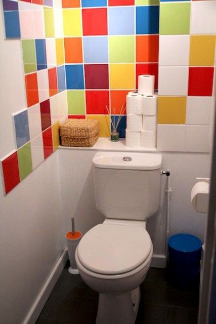A small and bright powder room refreshed with bright multi color tiles, with white appliances is a super cool and fresh idea to rock