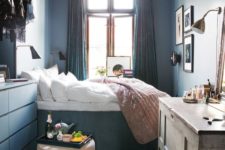 a small vintage-inspired bedroom with grey walls, a catchy chandelier, a storage bed and dresser, a makeshift closet