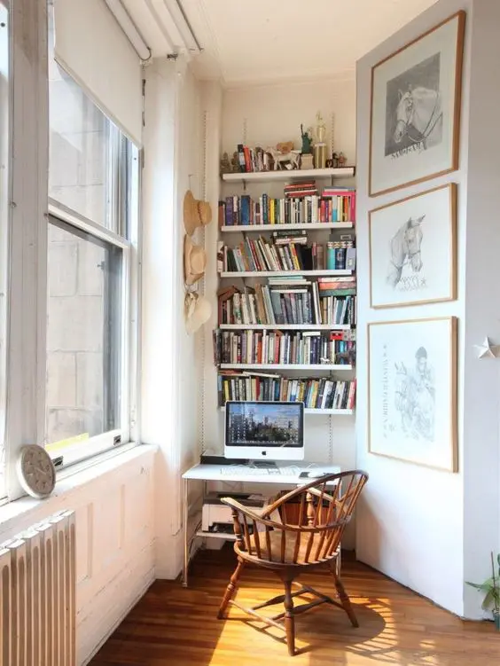 A small working nook with built in bookshelves, a small desk and a vintage chair is a stylish eclectic space