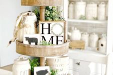 a spring farmhouse stand with greenery, beads, funny artworks of wood and a little gnome for kitchen decor
