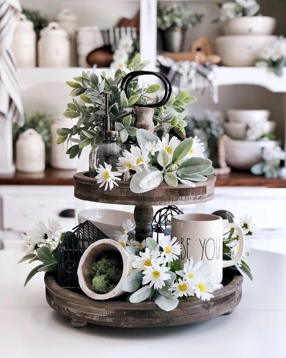 a spring kitchen stand of reclaimed wood, with pale greenery and blooms, moss and some mugs