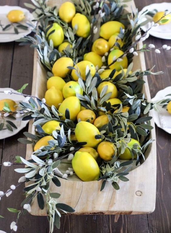 a spring or Easter centerpiece of a wooden breadbowl with lemons and willow