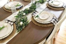 a spring or Easter tablescape with greenery runner, white tulips, wicker chargers and plaid napkins