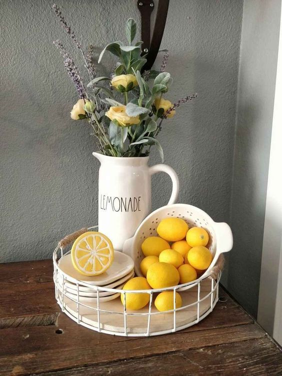 a stand with lemons, a toy lemon and an arrangement of greenery, yellow roses and lavender for spring decor