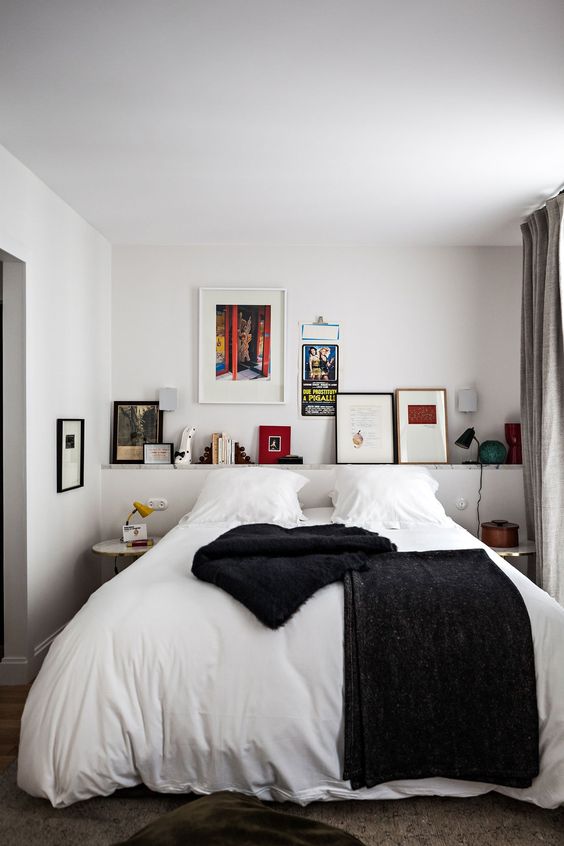 a stylish small bedroom with a cool gallery wall, a bed and mismatching nightstands for a chic look