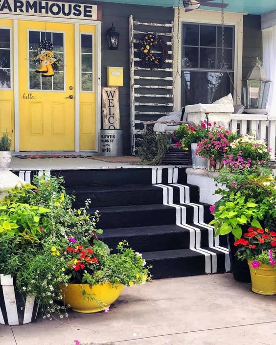 a super bright spring porch with potted blooms and greenery looks really cheerful and fun