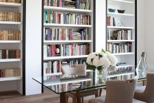 a super refined home office with built-in bookshelves with black framing to accent them as much as possible
