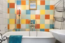 a tiny and colorful bathroom with a multi-color tile accent wall, white appliances and a turquoise towel is amazing