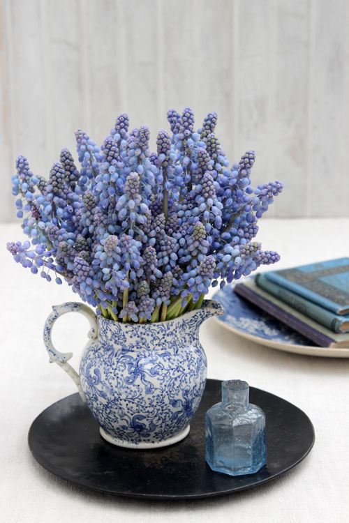 a vintage blue jug with blue and purple hyacinths is a refined vintage spring decoration to rock
