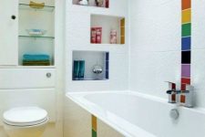a white bathroom with colorful tiles accenting the walls and shelves, a yellow floor and a skylight is a pretty and mood-raising idea