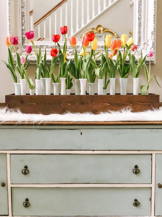 a wooden box, white textural vases and a whole arrangement of bright spring tulips is a bold decoration for spring