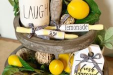 a wooden stand with faux lemons, greenery and potted greenery plus some lemonade signs for a spring feel